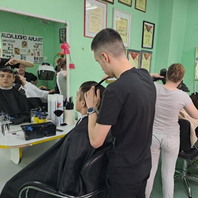 A secondary school student training in a hairdressing workshop